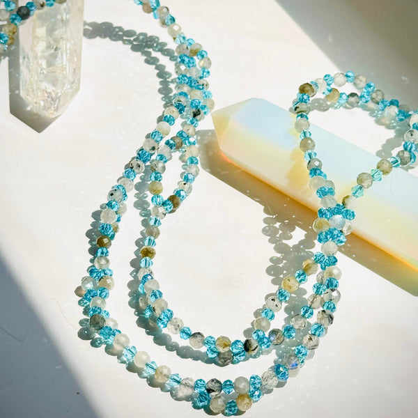 Beaded moonstone tantric necklace with blue beads on white surface