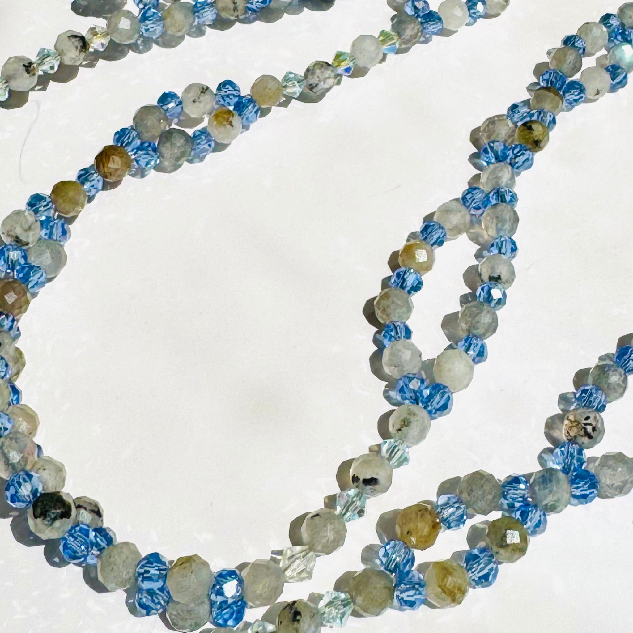 Beaded Moonstone tantric necklace on white surface with blue beads