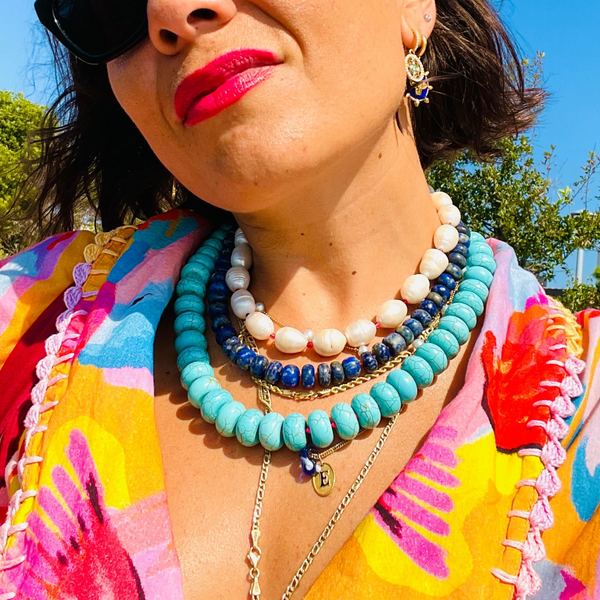 Model wearing turquoise,lapis and pearl necklace with colorful shirt