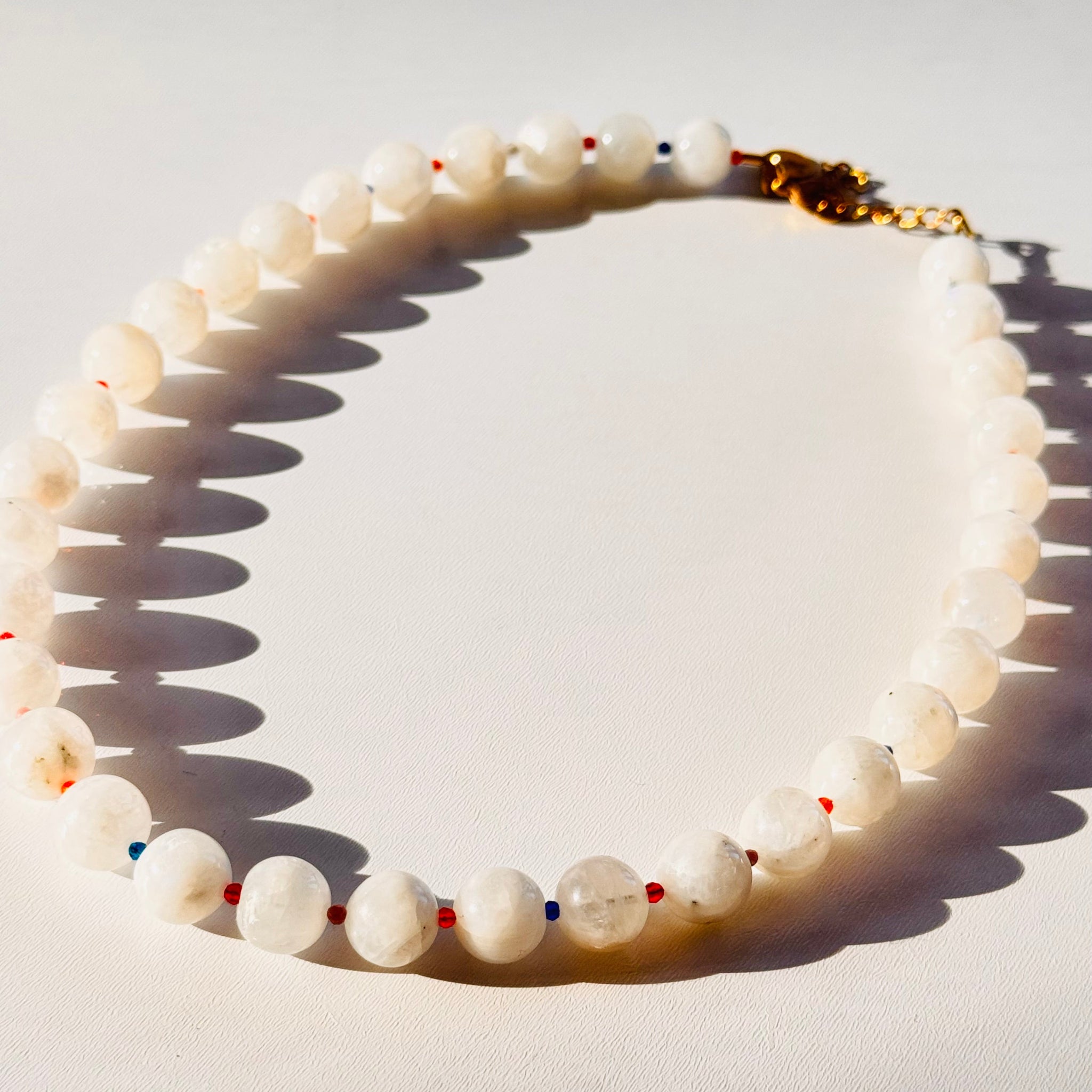 Beaded necklace with small colored beads on a light background closeup image