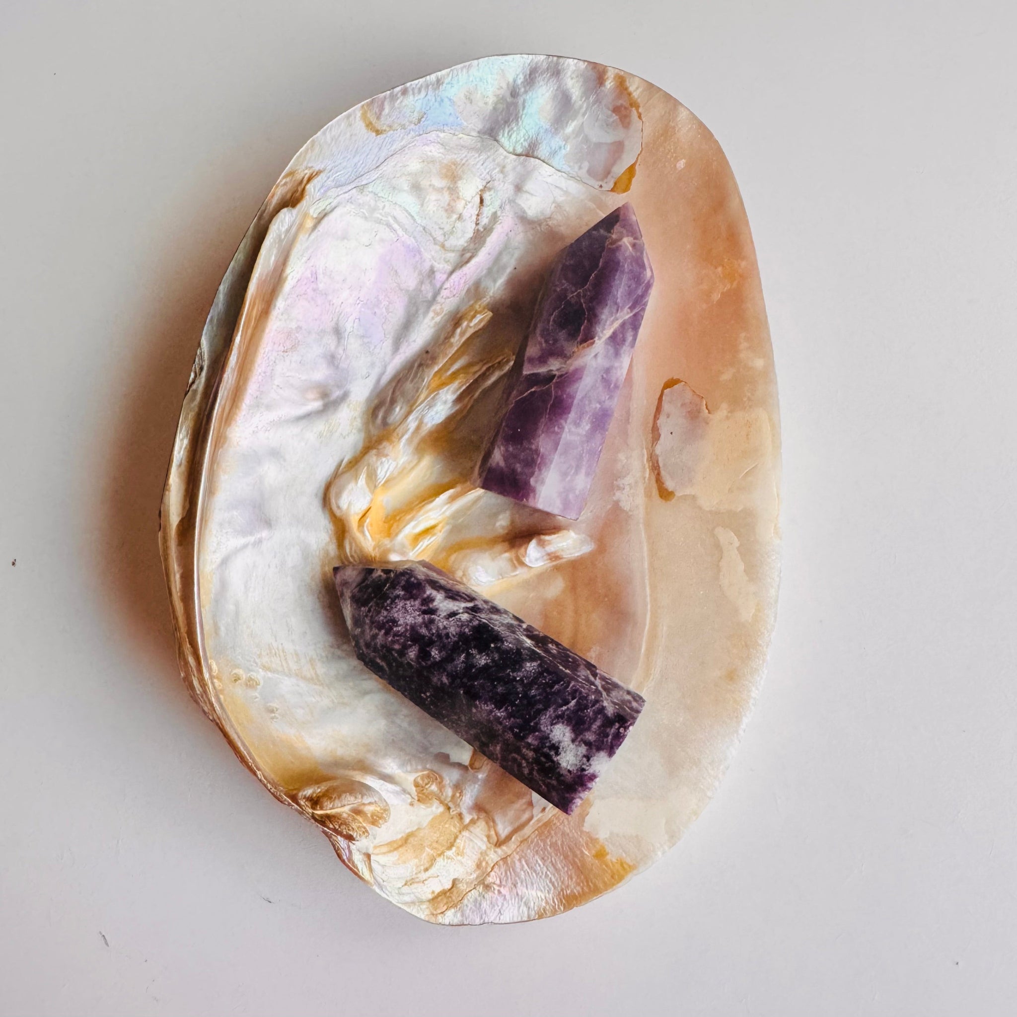 Polished stone with purple crystals embedded on a light gray background