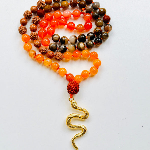 A collection of beaded necklaces with a brass serpent pendant.