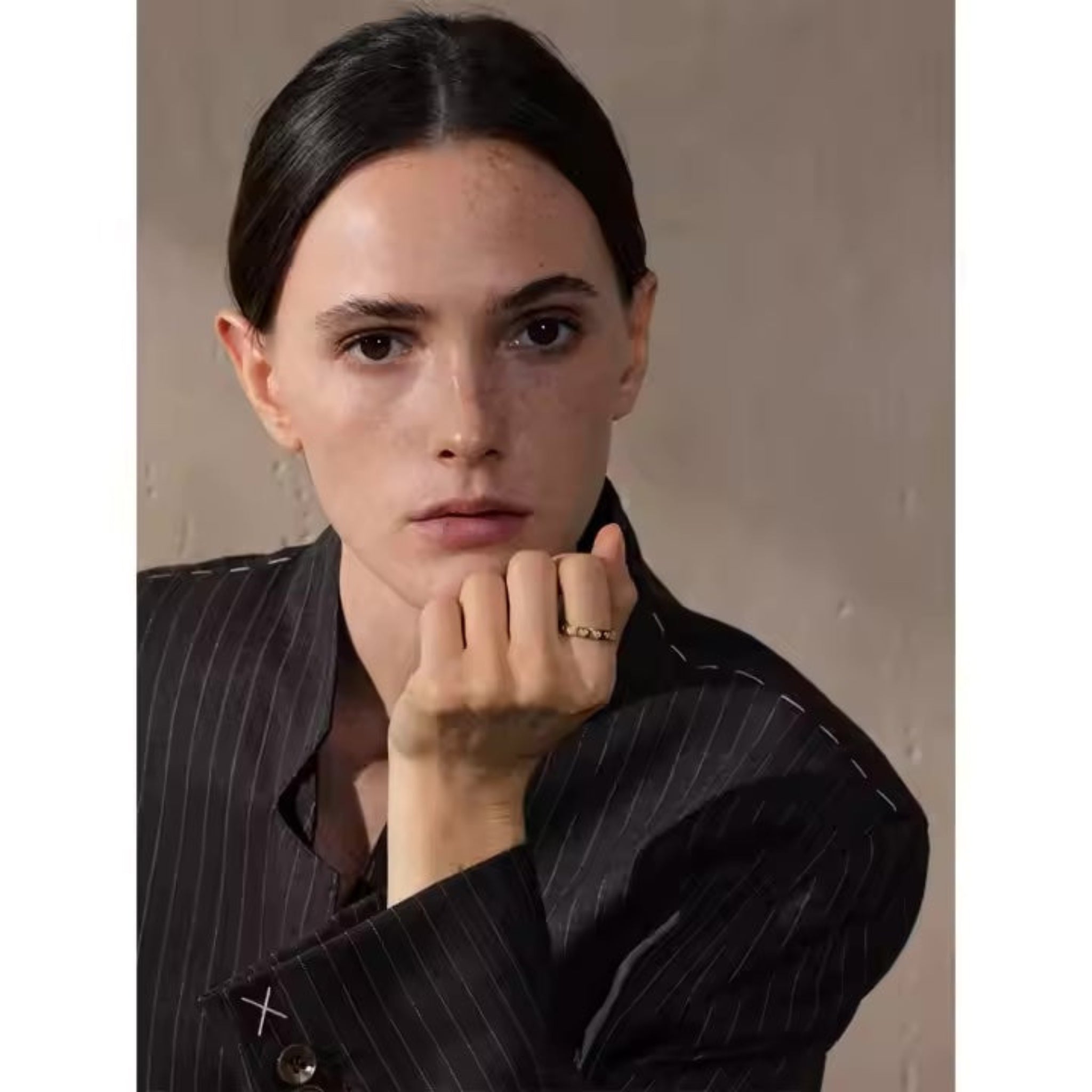 Person wearing a pinstripe shirt against a plain background