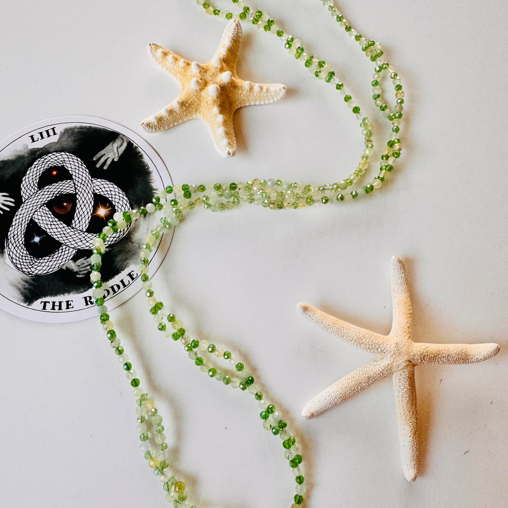 Green tantric necklace with stars and a decorative card