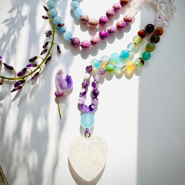Closeup photo of beaded necklace with purple,blue and white beads with white crystal pendant