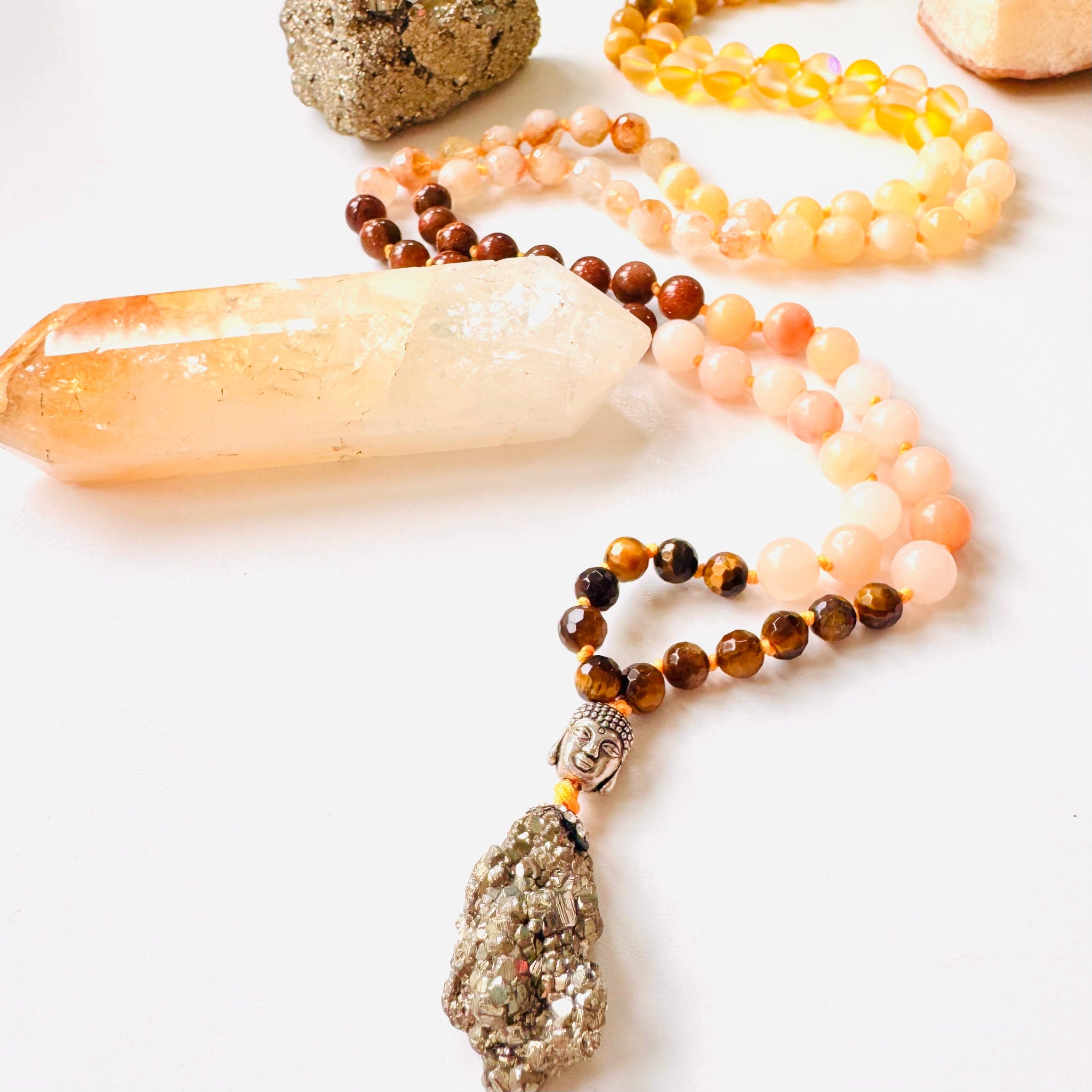 Necklace with beads and crystal pendant on a white surface