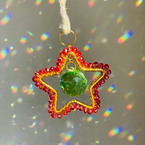A mini star-shaped suncatcher with a central purple crystal and gold-tone metal frame, surrounded by clear crystals and a green chain for hanging.