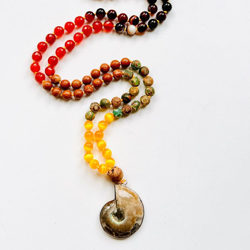 A multicolored beaded mala with a variety of colorful beads and a central ammonite pendant, designed for meditation and personal empowerment.