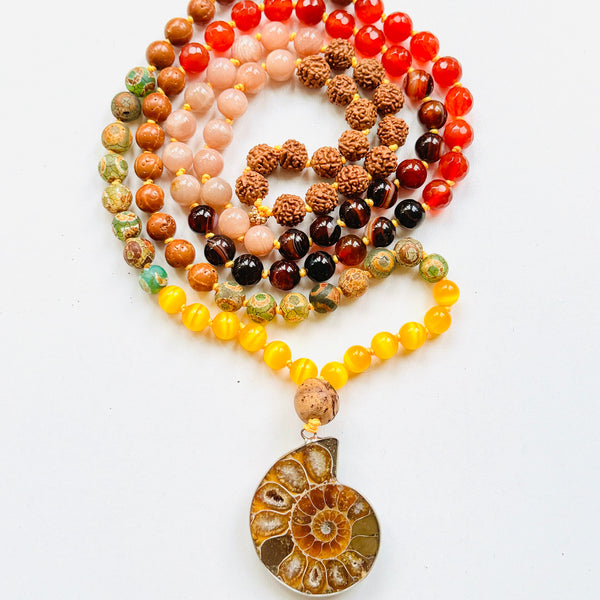 A multicolored beaded mala with a variety of colorful beads and a central ammonite pendant, designed for meditation and personal empowerment.