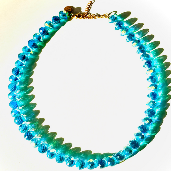 shimmering crystal necklace on white surface