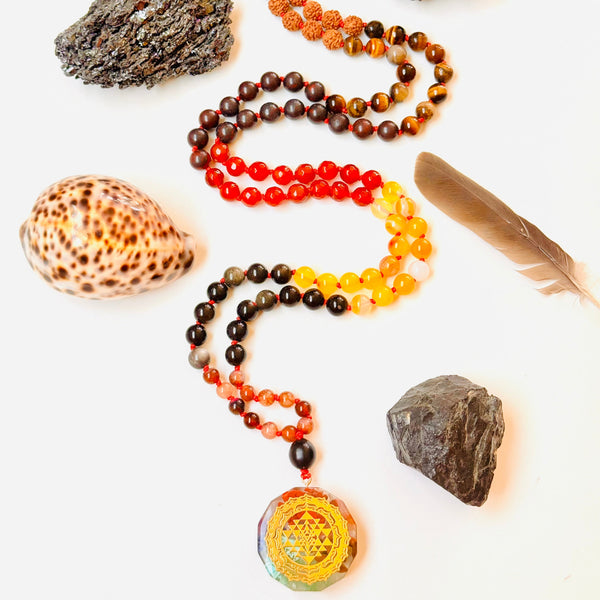 Beaded necklaces with stones and a feather on a white background