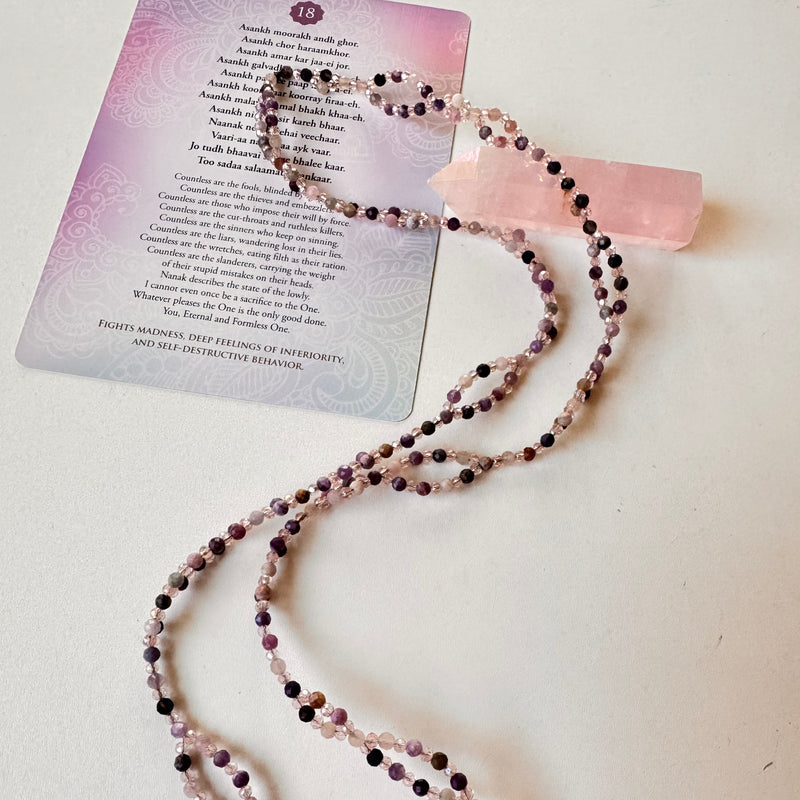 Lepidolite Tantric Necklace with mantra card and pink crystal on white surface
