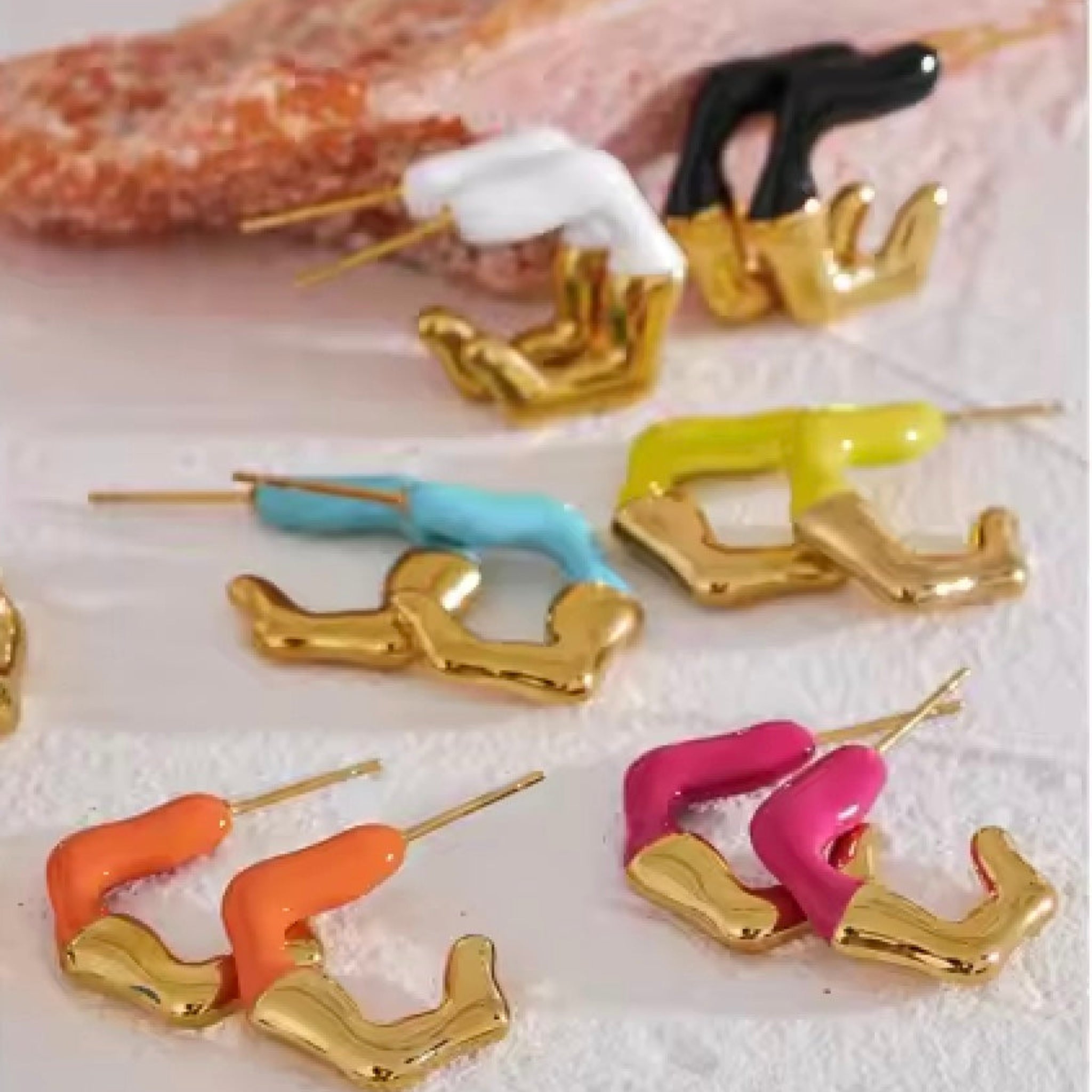 Colorful earrings on a textured surface