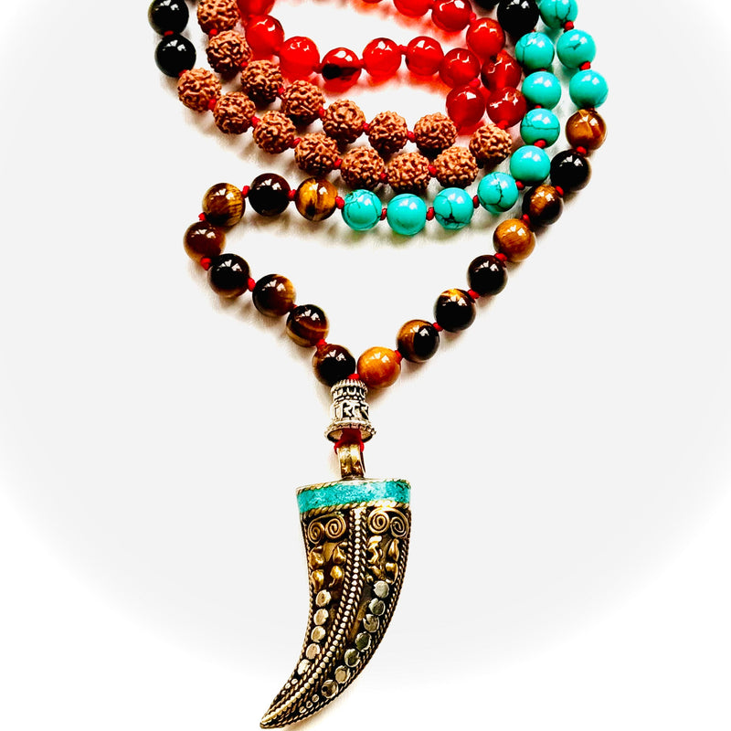 A variety of colorful gemstone beads and a Tibetan horn pendant, arranged on a white background.