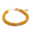 Gold bracelet with yellow beads on a white background