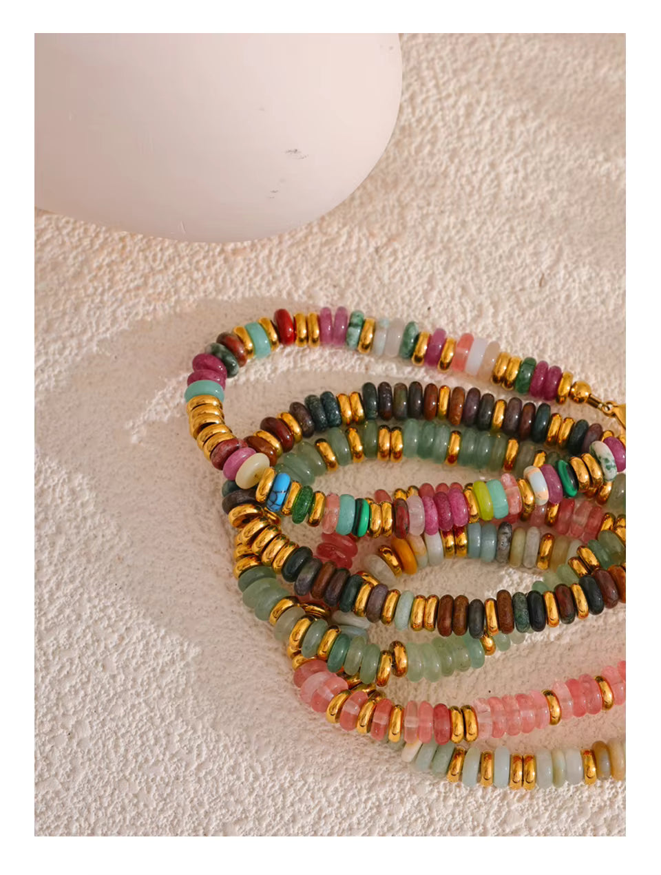 Colorful beaded bracelets on a textured surface