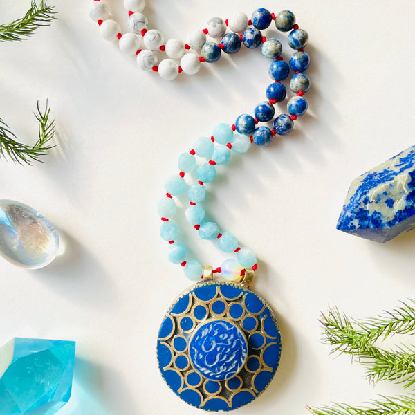 Beaded blue and white gemstone necklace with brass pendant and crystals