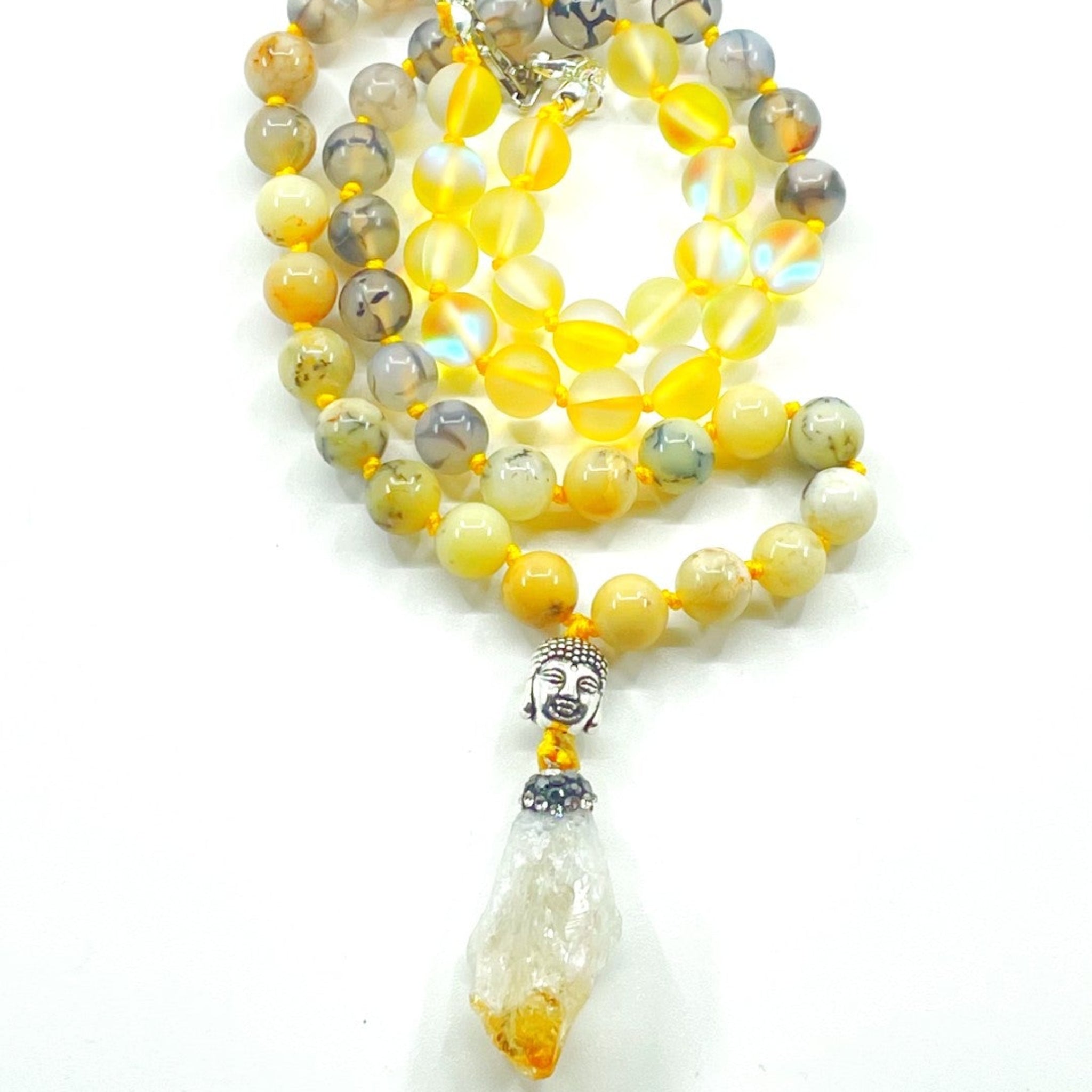 A colorful half mala necklace with yellow and clear gemstone beads, a citrine pendant, and a yellow opal bead.