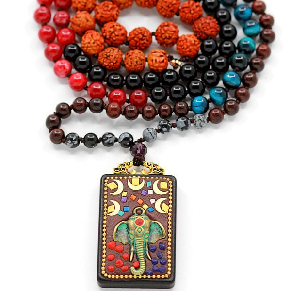 A multicolored beaded mala with a red and black circular pattern, a brown elephant-shaped pendant, and beads with various colors including blue and black.
