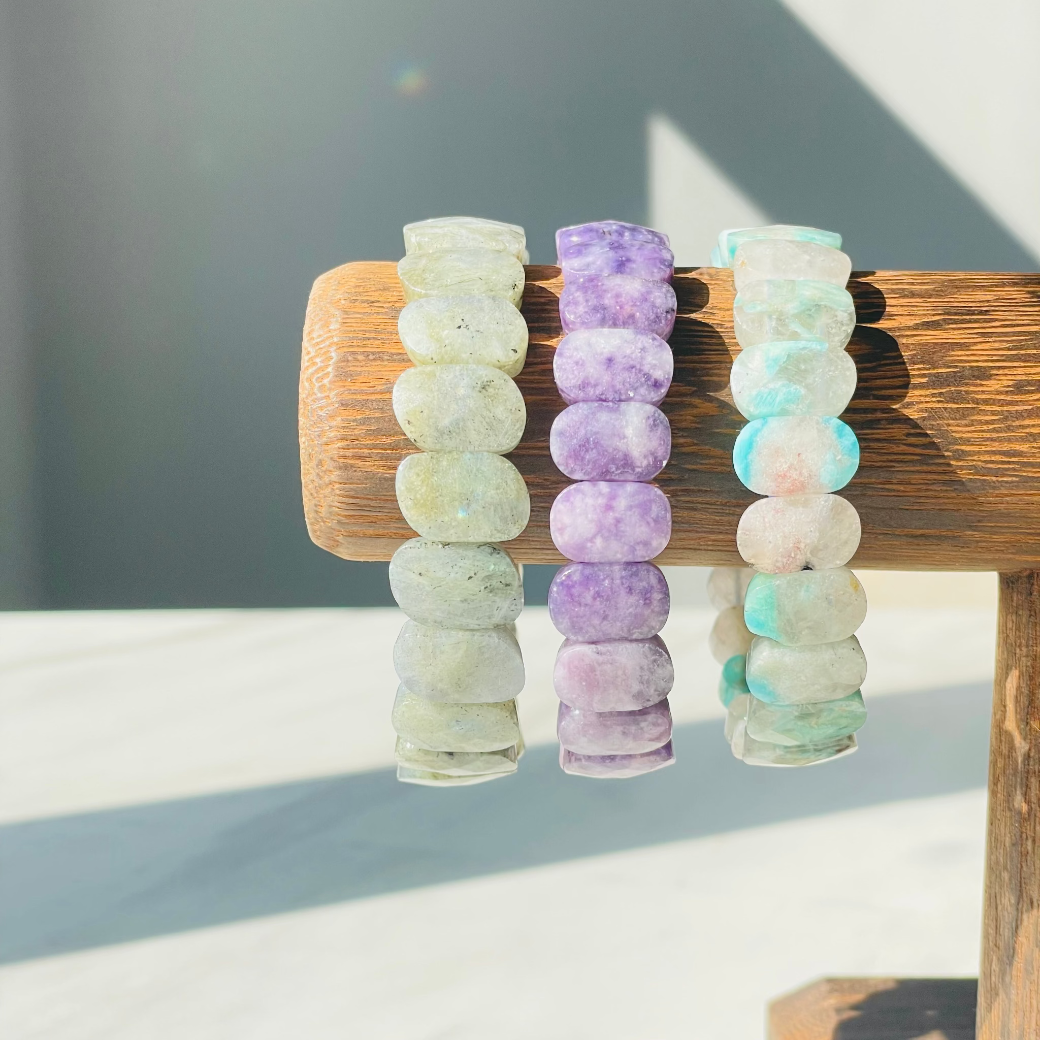 Labradorite Lepidolite Amazonite bracelets on wood display