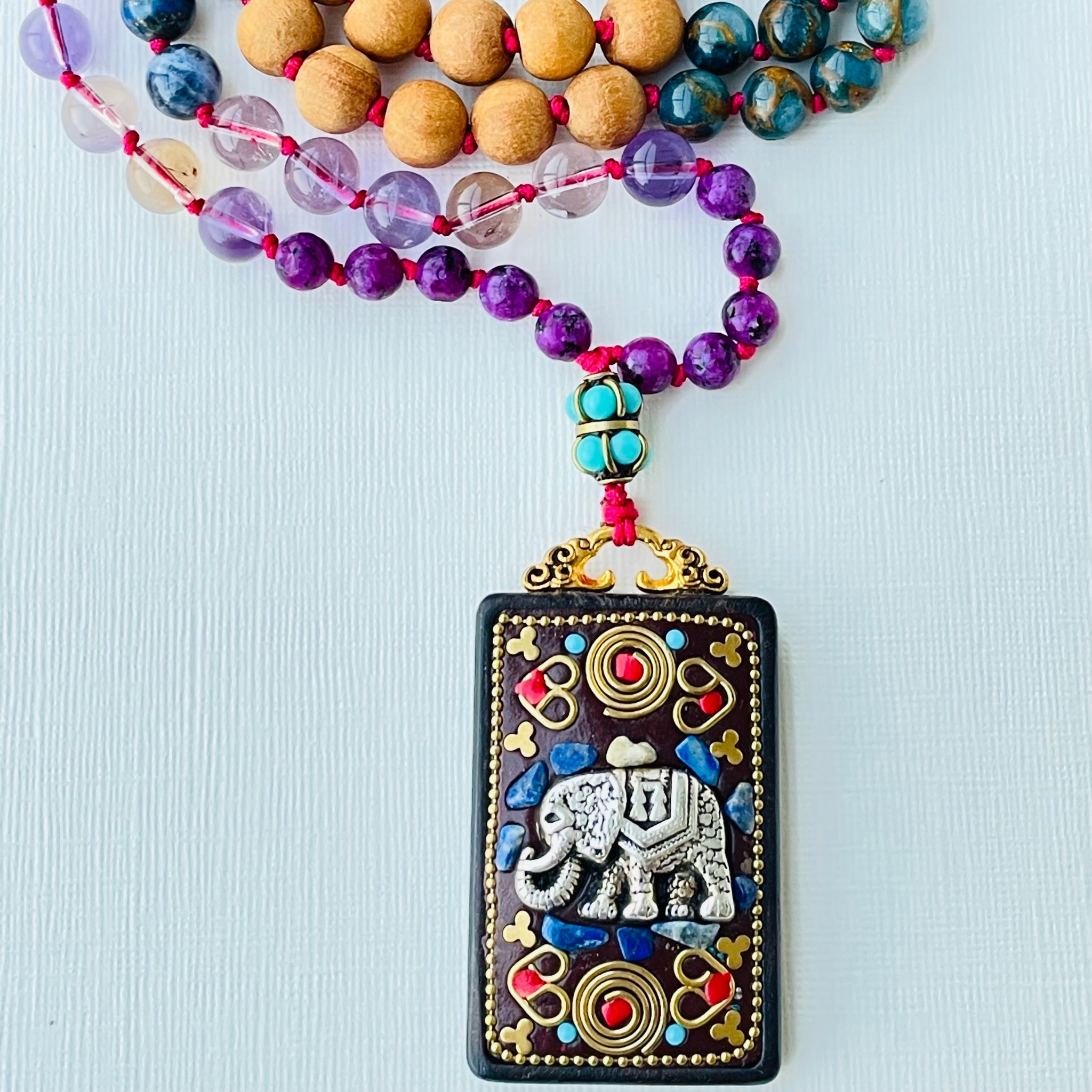 closeup photo of remover of obstacles mala beaded gemstones with elephant pendant