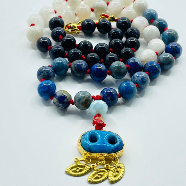 Closeup image of beaded necklace with blueand white beads on white surface