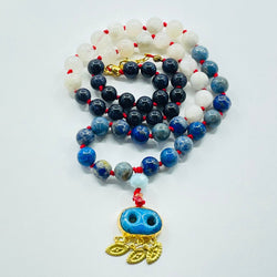 Beaded blue and beads with evil eye pendant on white surface
