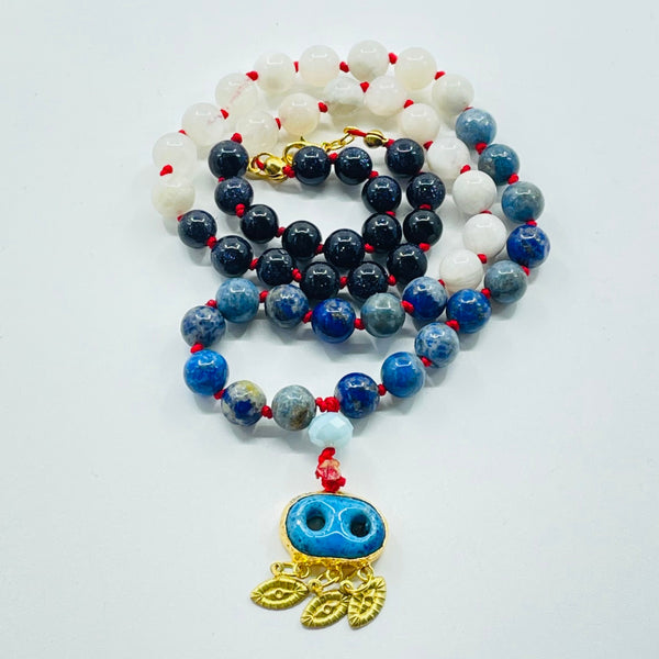 Beaded blue and beads with evil eye pendant on white surface
