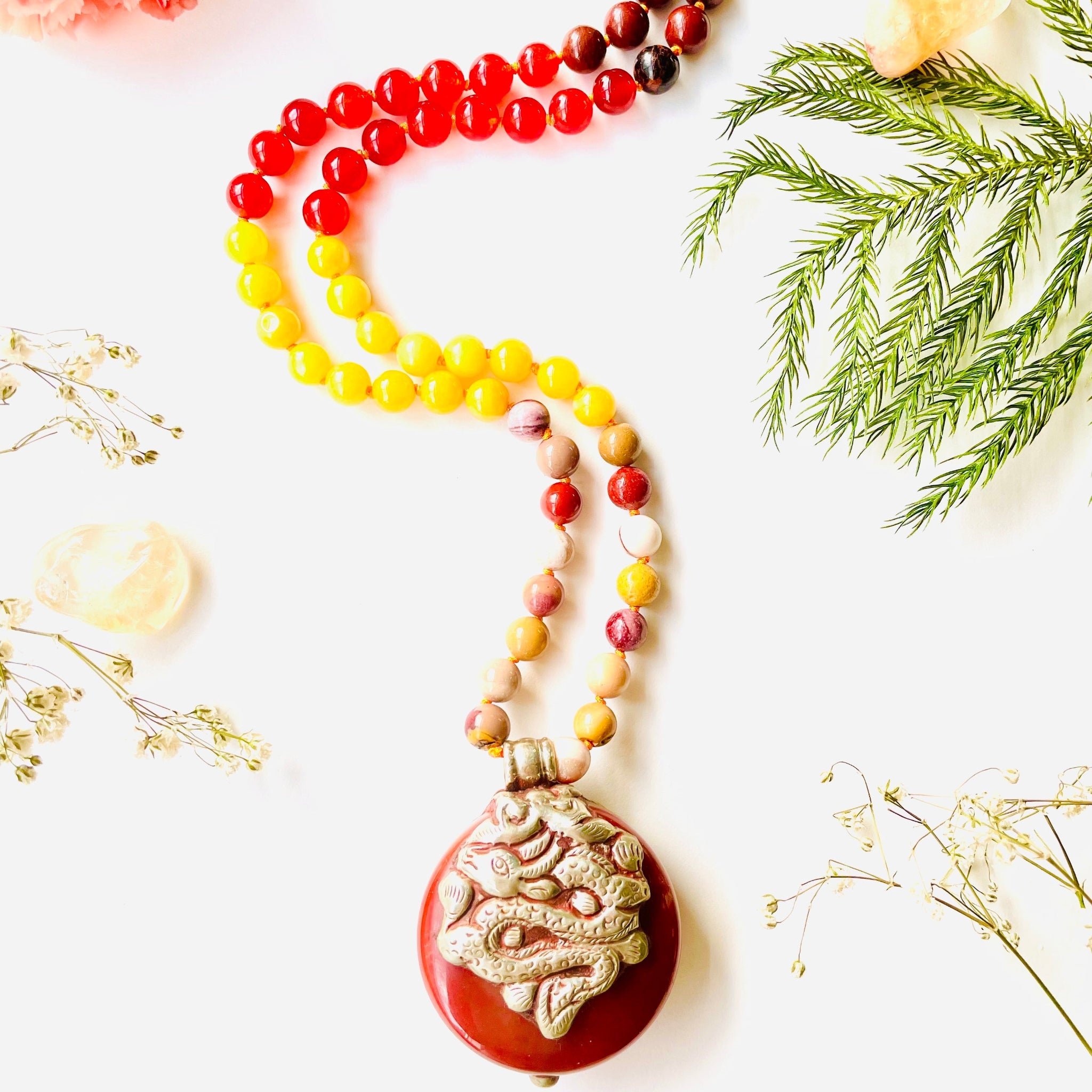 A beaded necklace with a vintage brown agate pendant, featuring a variety of colorful gemstone beads and a silver-colored pendant.