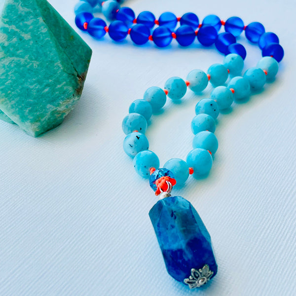 beaded blue gemstones on orange silk thread upclose photo