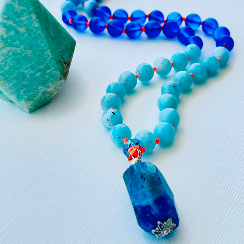 beaded blue gemstones on orange silk thread upclose photo